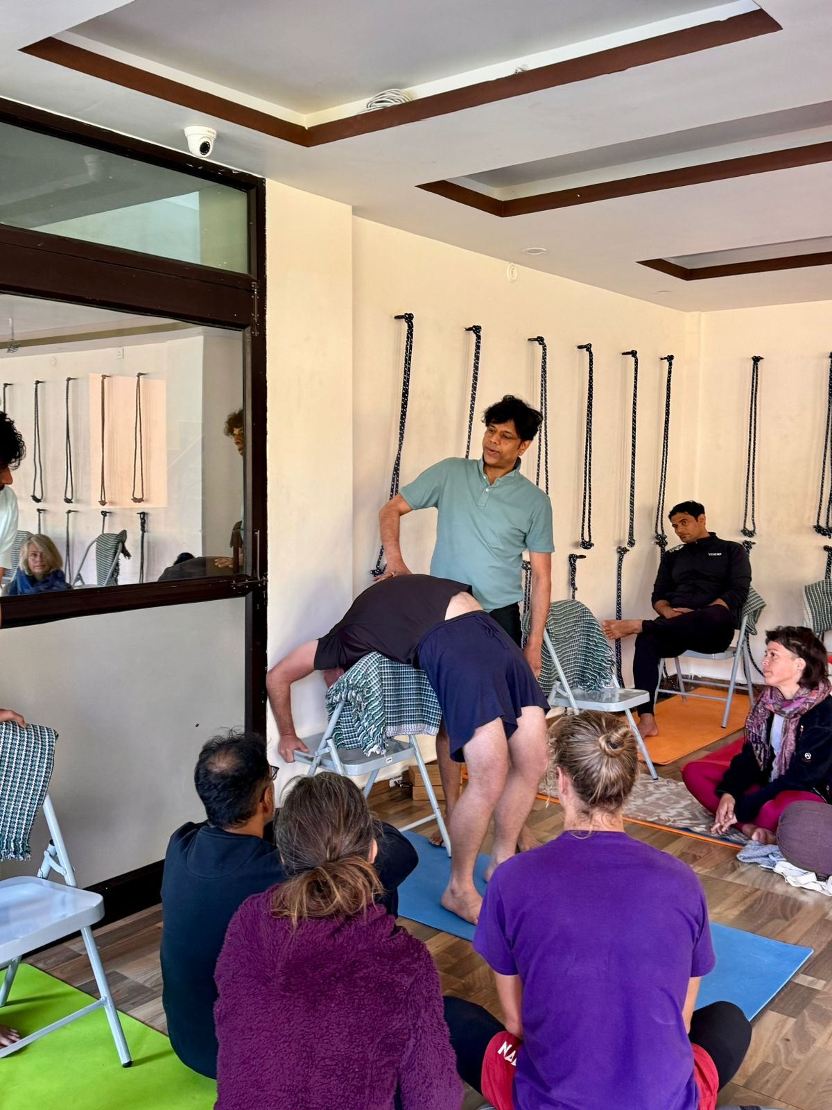 Pankaj Sharma unterrichtet eine unterstützte Rückbeuge während des Yoga-Intensivkurses in Rishikesh